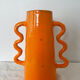 Handmade abstract orange ceramic vase with wavy handles