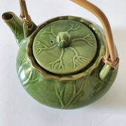Vintage green teapot with lotus decoration and bamboo handle.