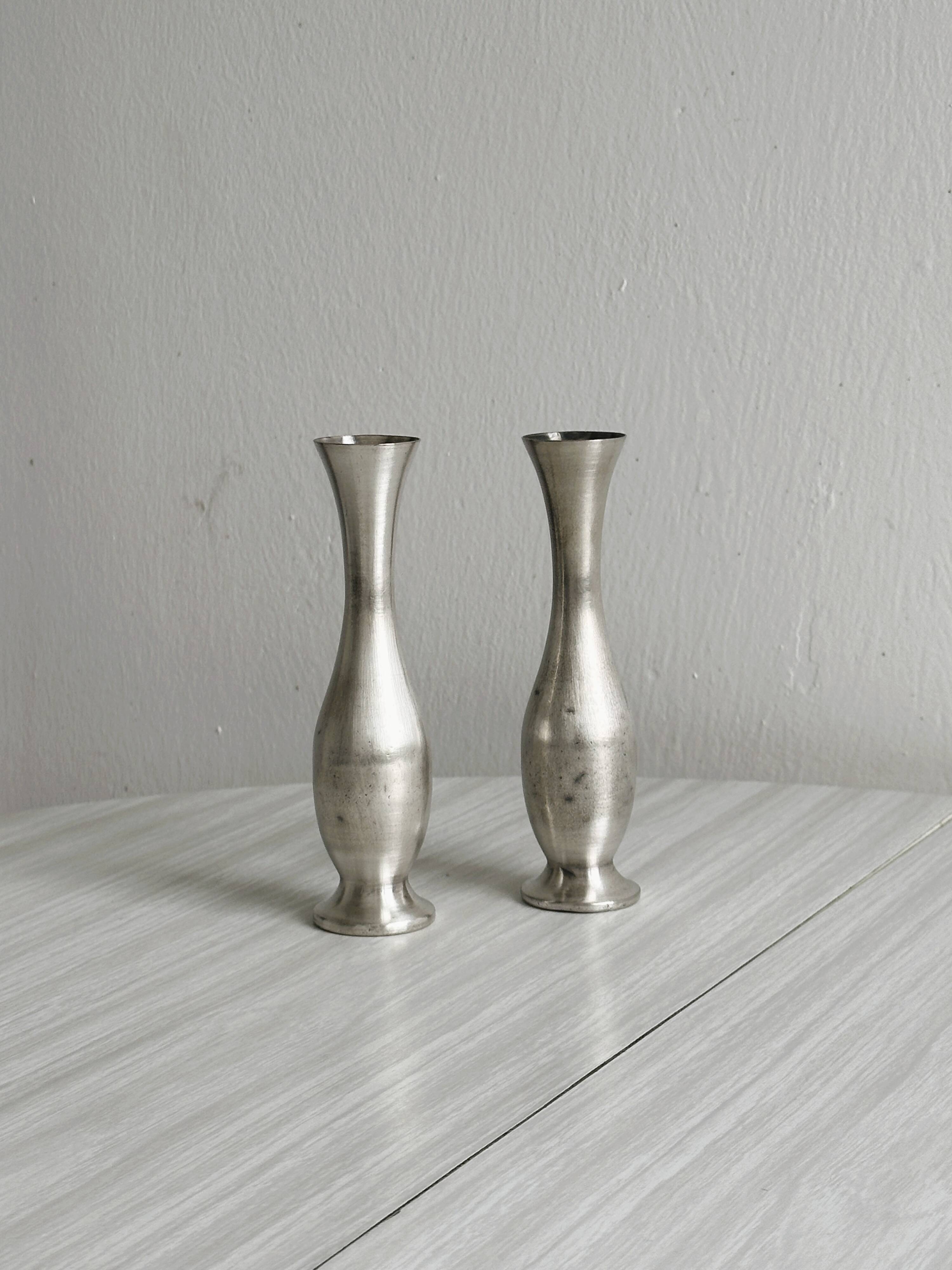 2 shiny metal vases
