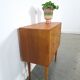 Commode danoise avec de hauts pieds et des poignées dorées.