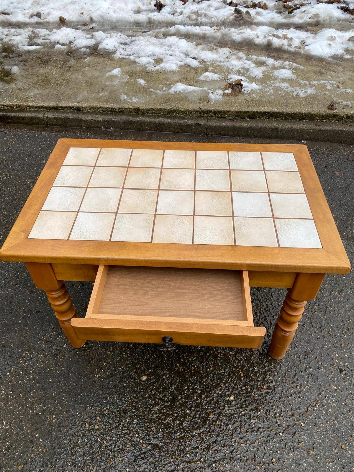 Light solid wood coffee table with tiles and a drawer.