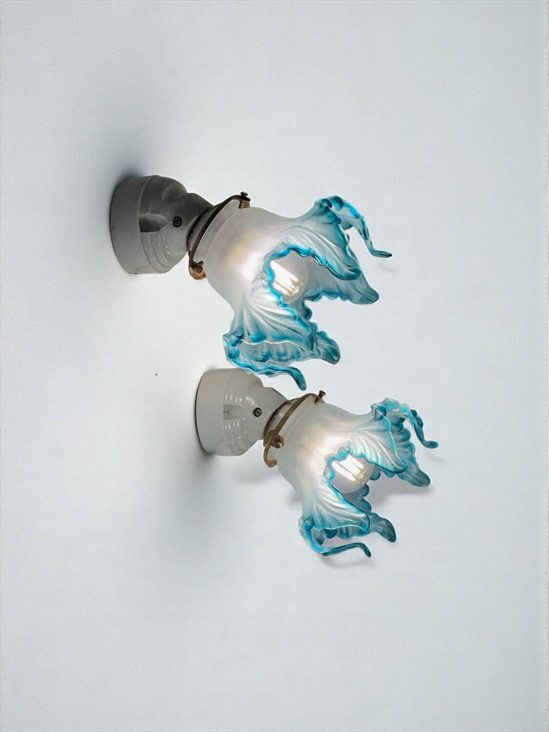Pair of wall lights with porcelain feet and blue glass tulips in Art Deco style.