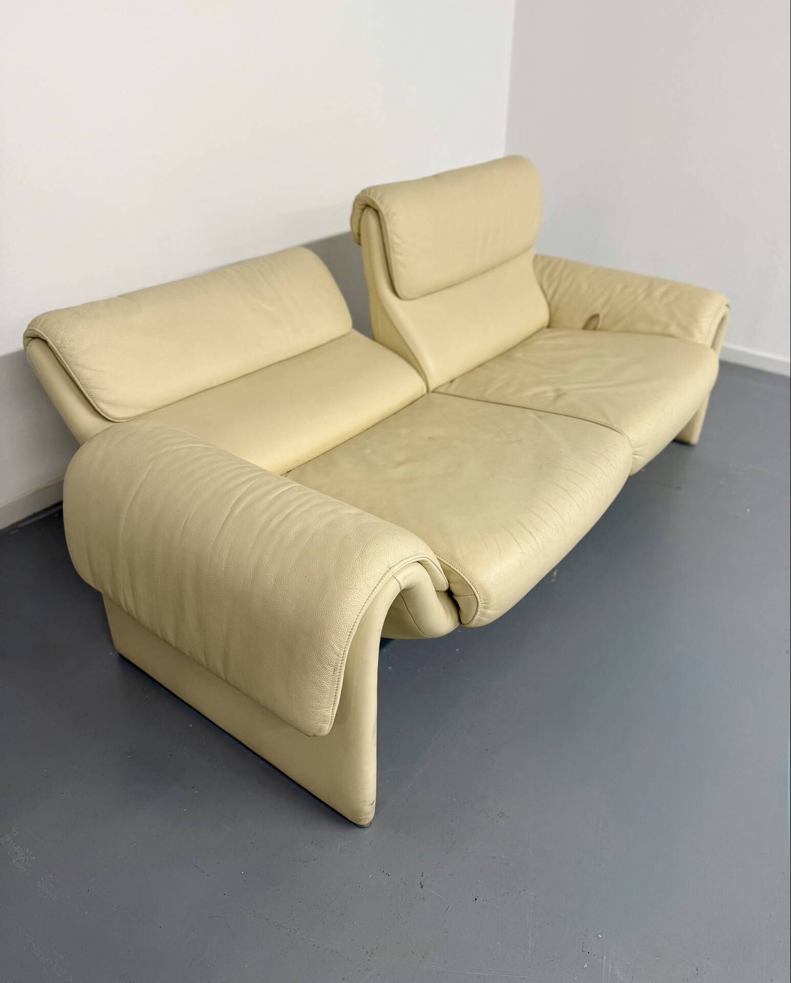 Two-seater designer sofa De Sede DS-2011 in cream leather with adjustable backrest.