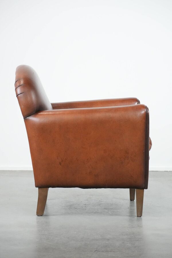 Fauteuil en peau de mouton au design art déco avec des couleurs intemporelles et chaleureuses.