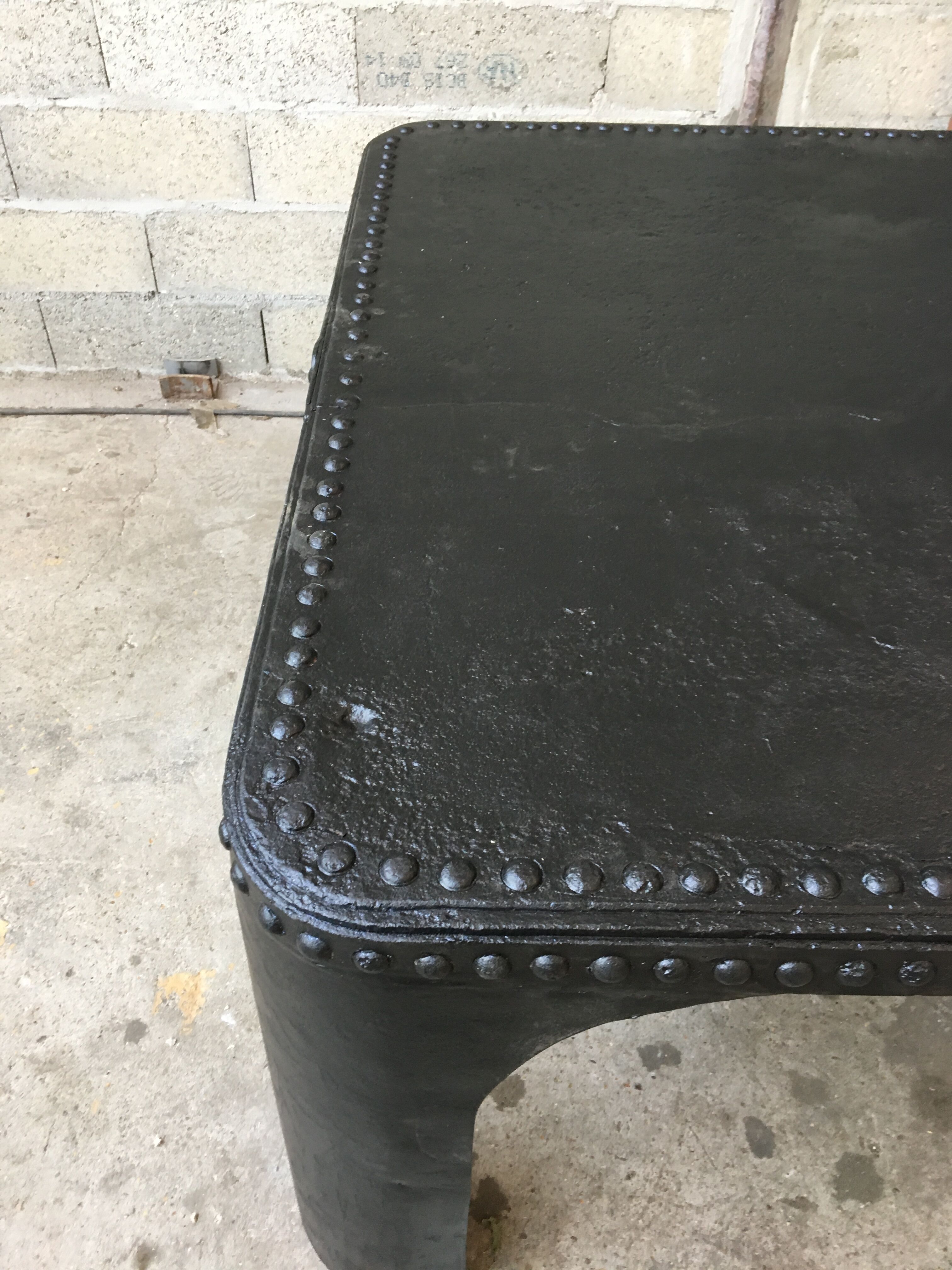large industrial table in graphite black riveted metal