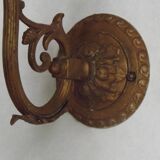 French Art Nouveau wall sconce in bronze with a white and pink glass shade.