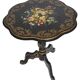 Blackened wooden side table decorated with a painted bouquet of flowers.