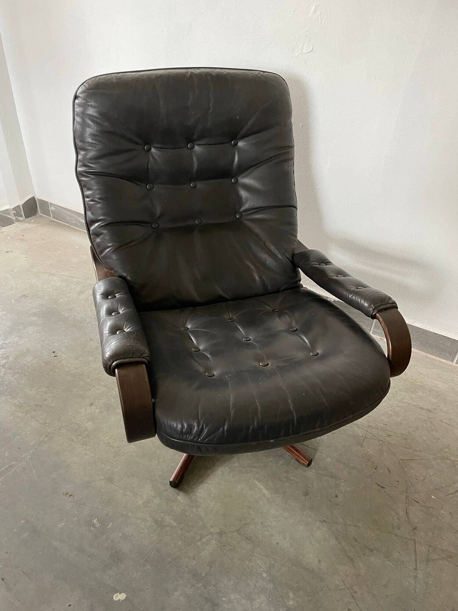 Scandinavian swivel lounge chair in black leather with a bent wood frame, 1970s.