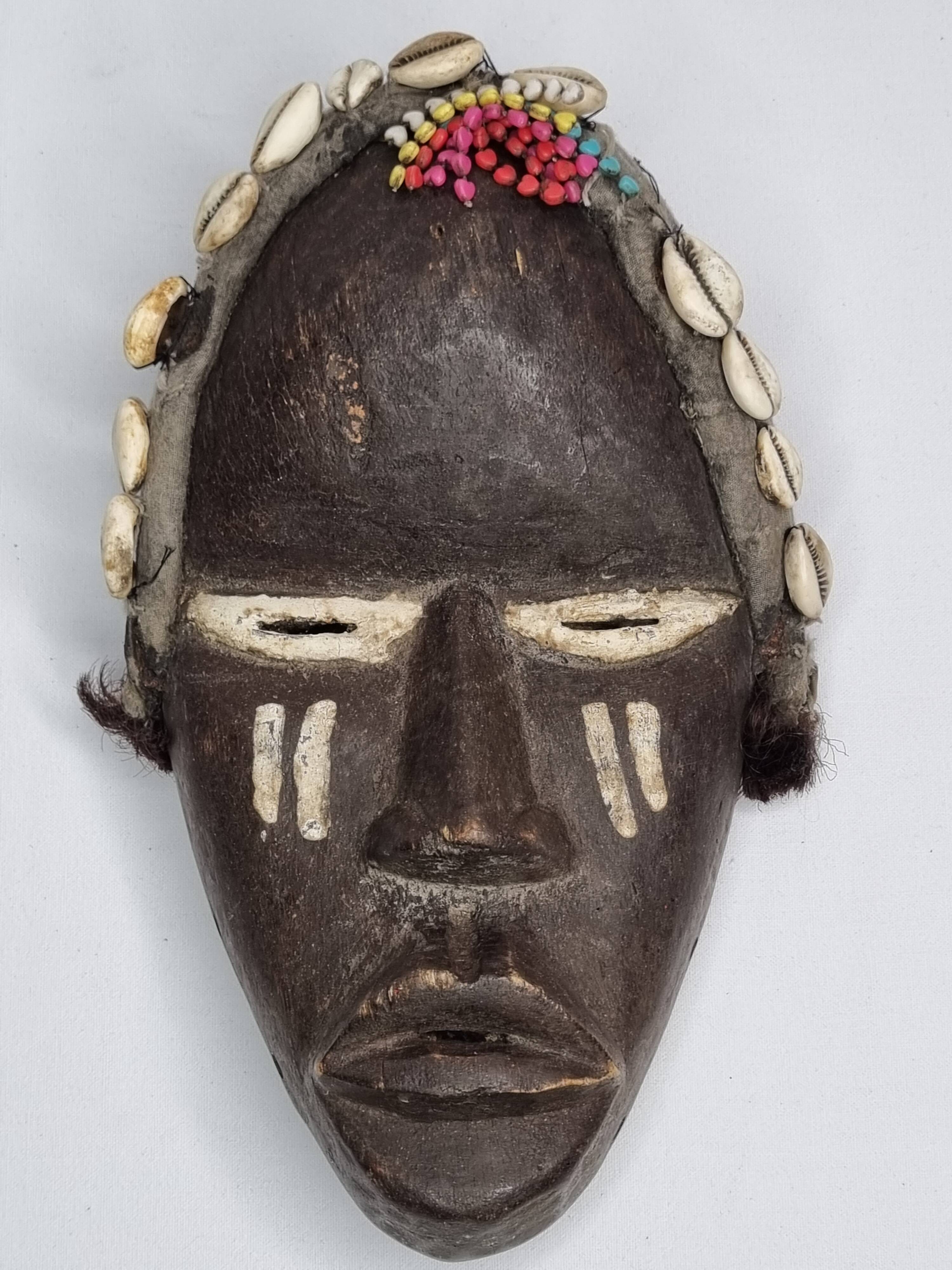 Tribal Dan mask in wood and cowrie shells, West Africa, 27 cm