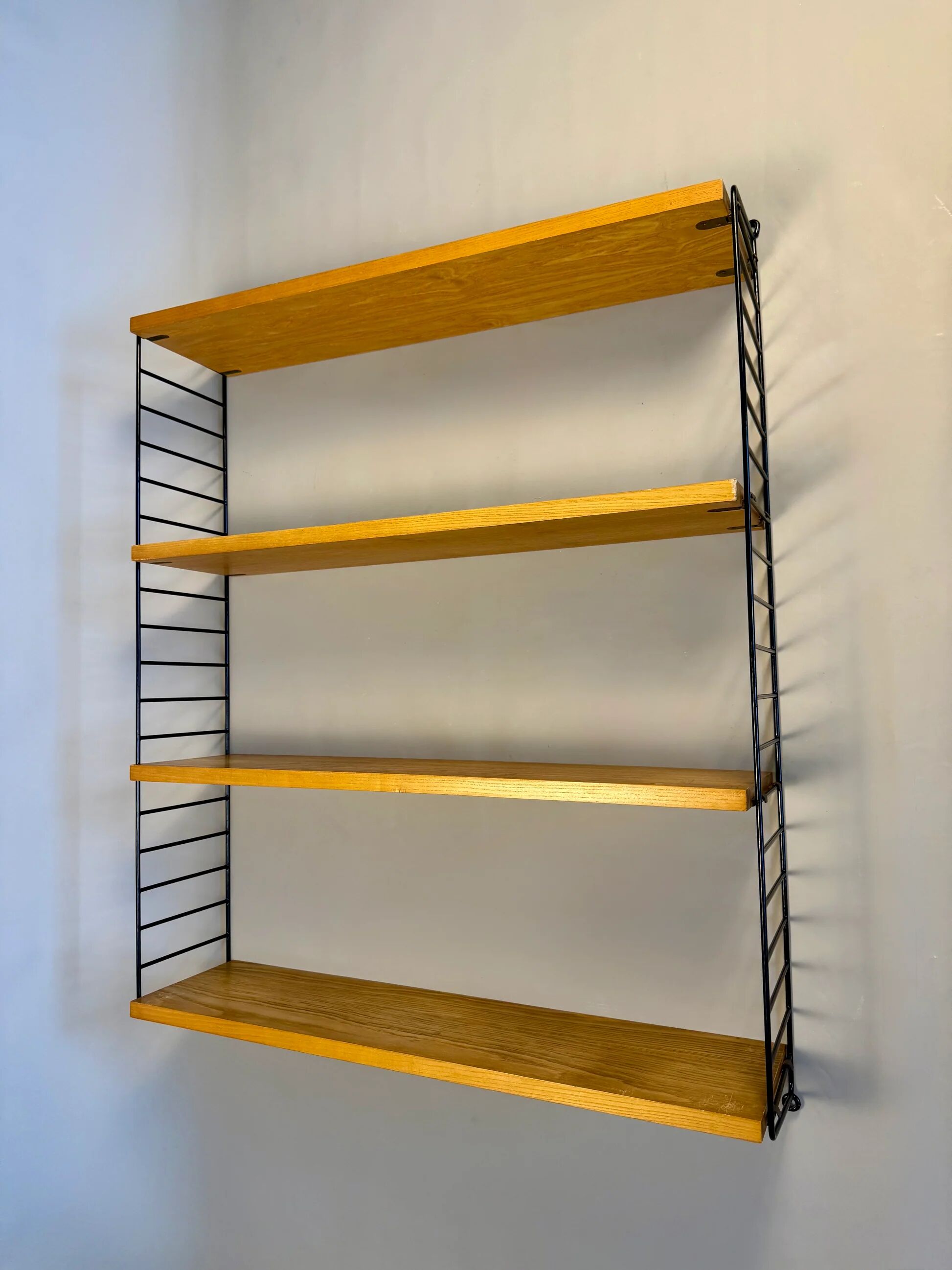 Floating wall shelf in oak veneer and black metal, 1960s.