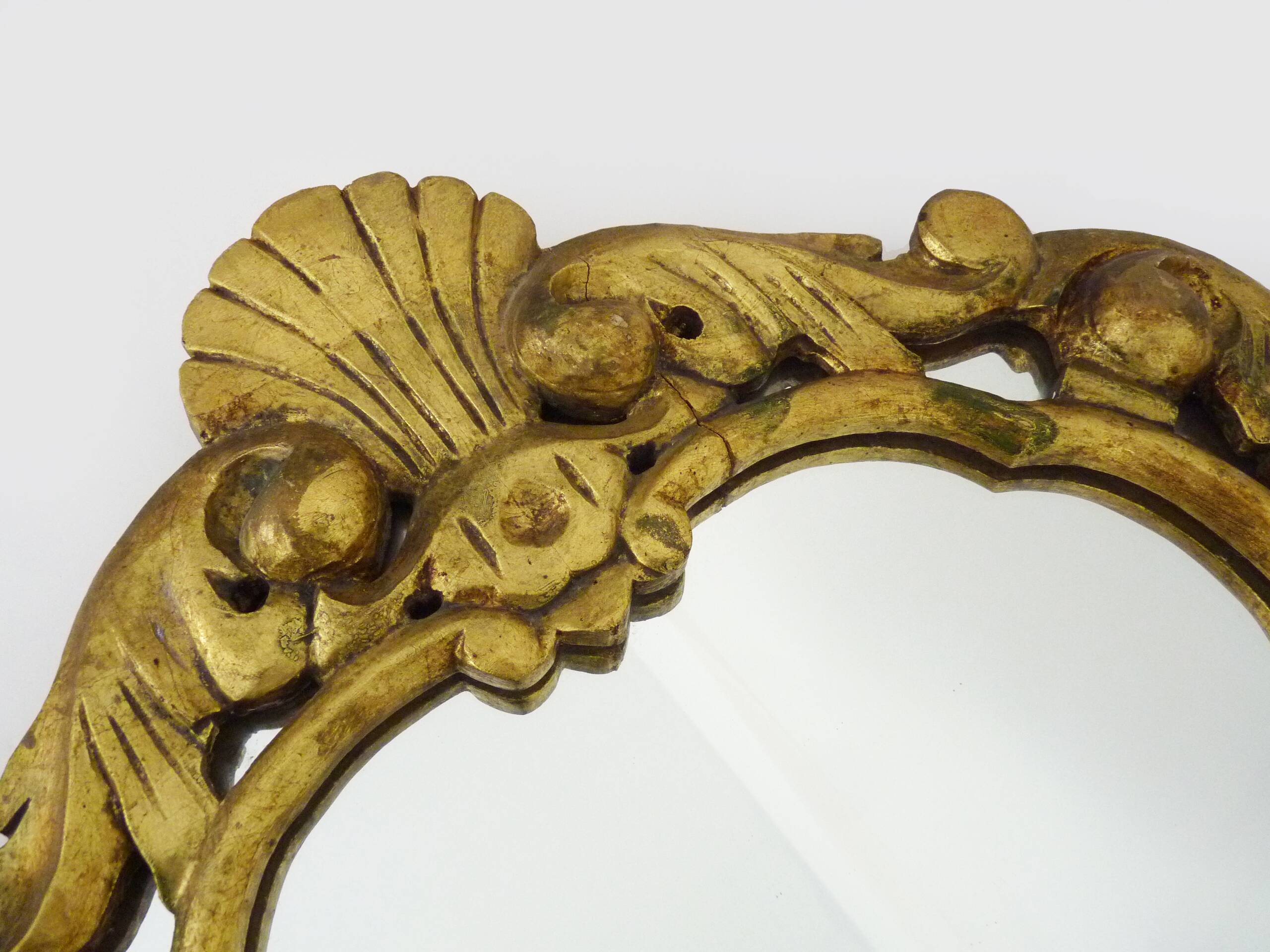 Old wall mirror in wood and gilded stucco with shell decoration, Louis XV style pediment mirror