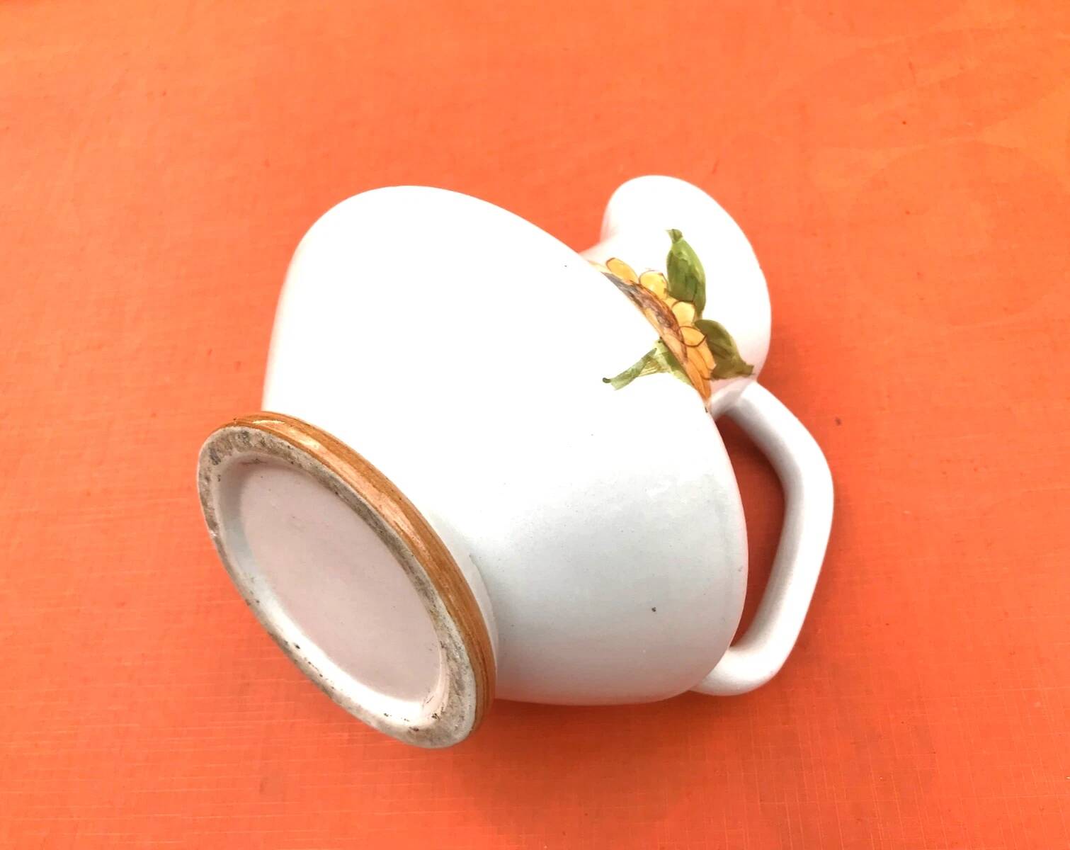 Antique glazed ceramic pitcher with sunflower decoration