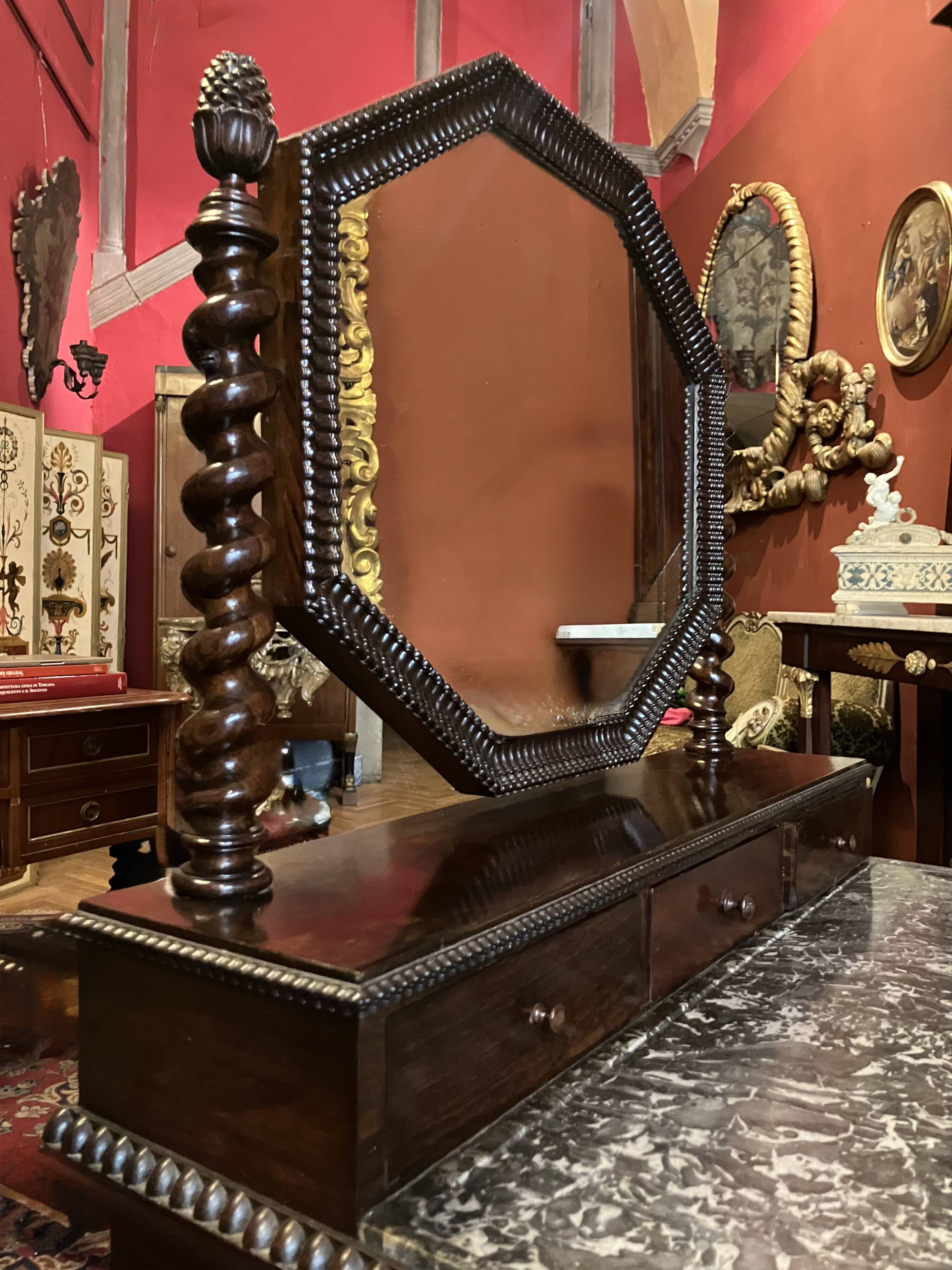 Antique English mahogany dressing table with carved details, black marble, and mirror.