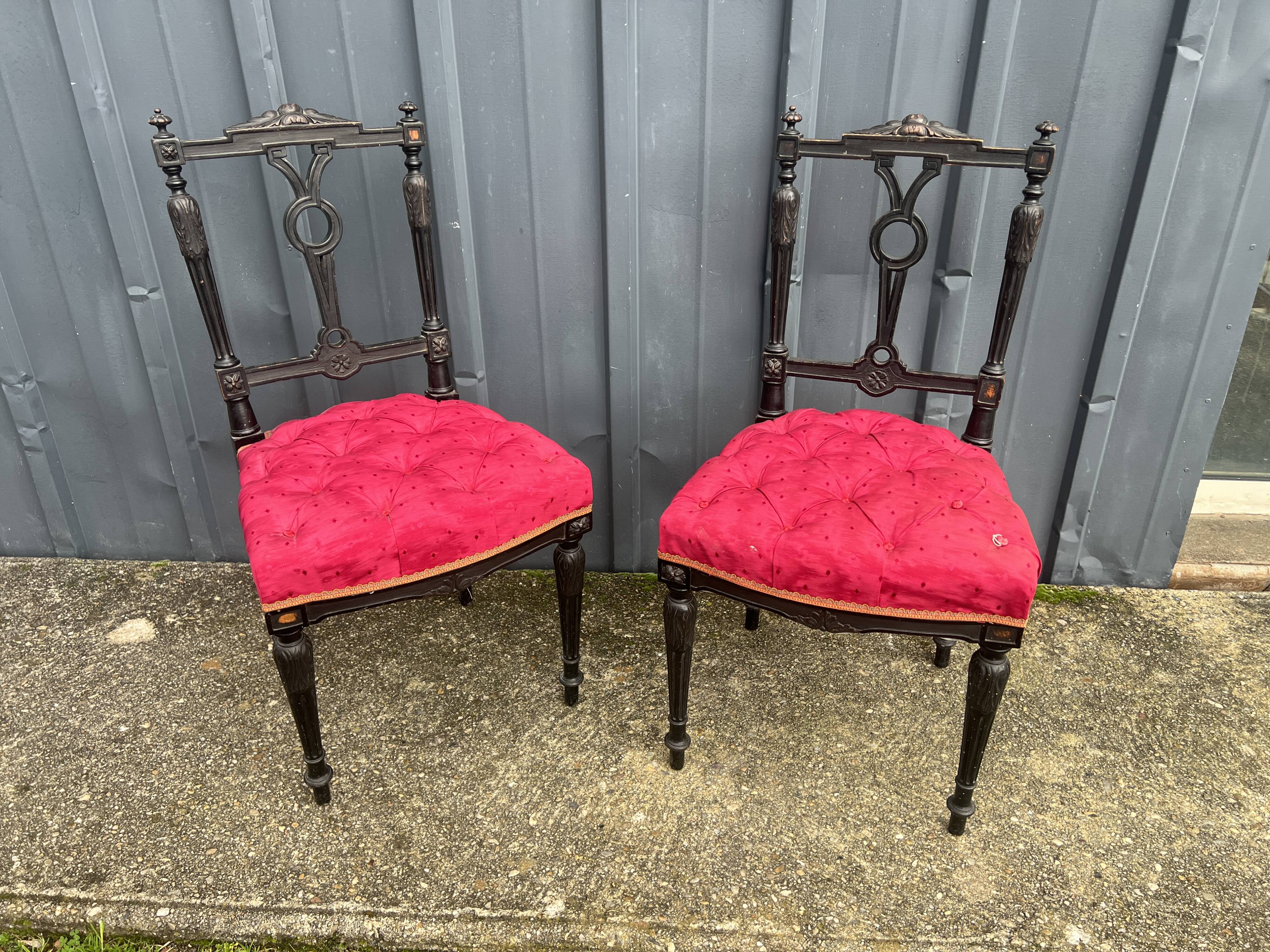 Pair of black lacquered chairs with purple tufted upholstery.