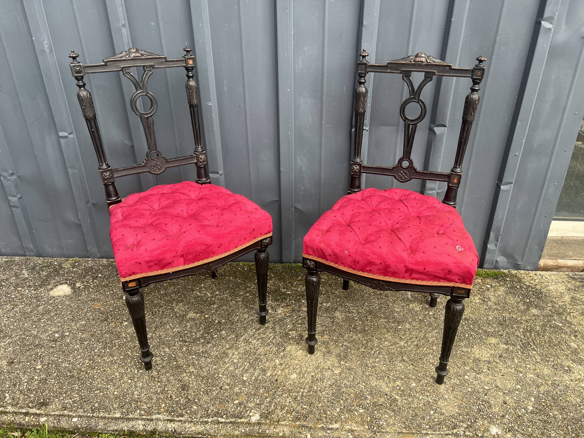 Pair of black lacquered chairs with purple tufted upholstery.