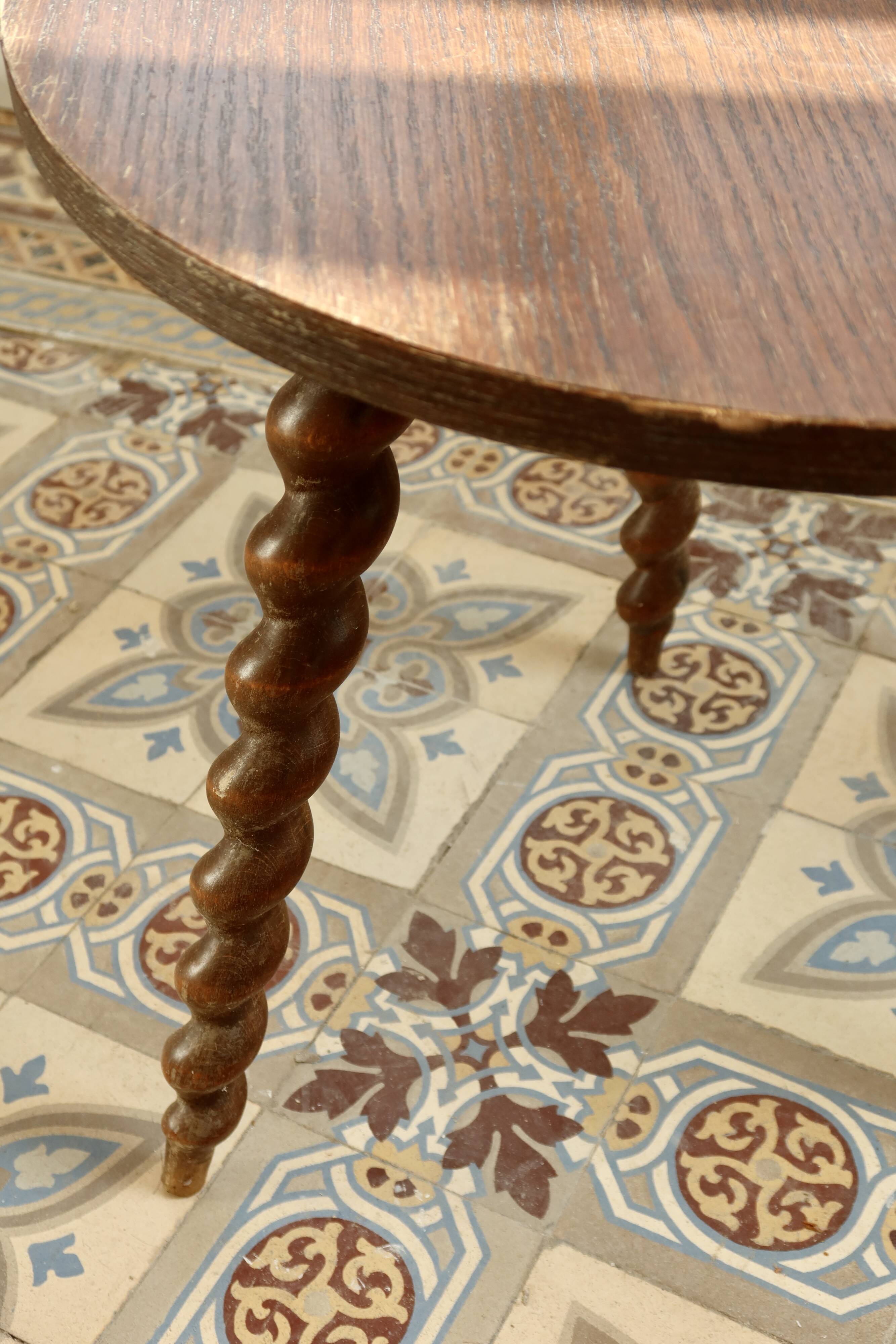 Vintage circular side table in wood with turned legs.