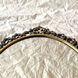 Old oval wall mirror in gilded brass