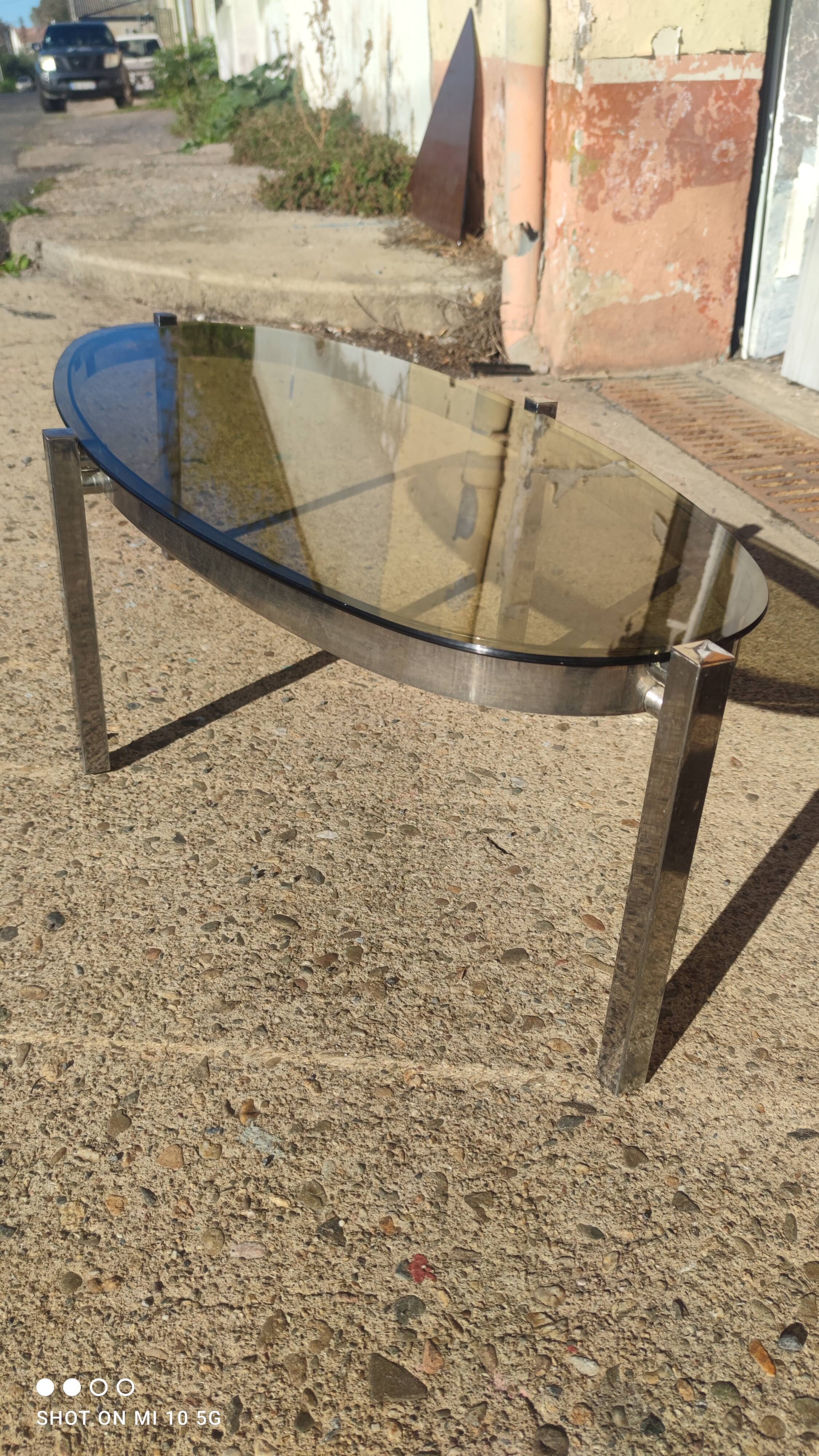 Table basse elliptique vers 1970 en métal chromé et verre fumé