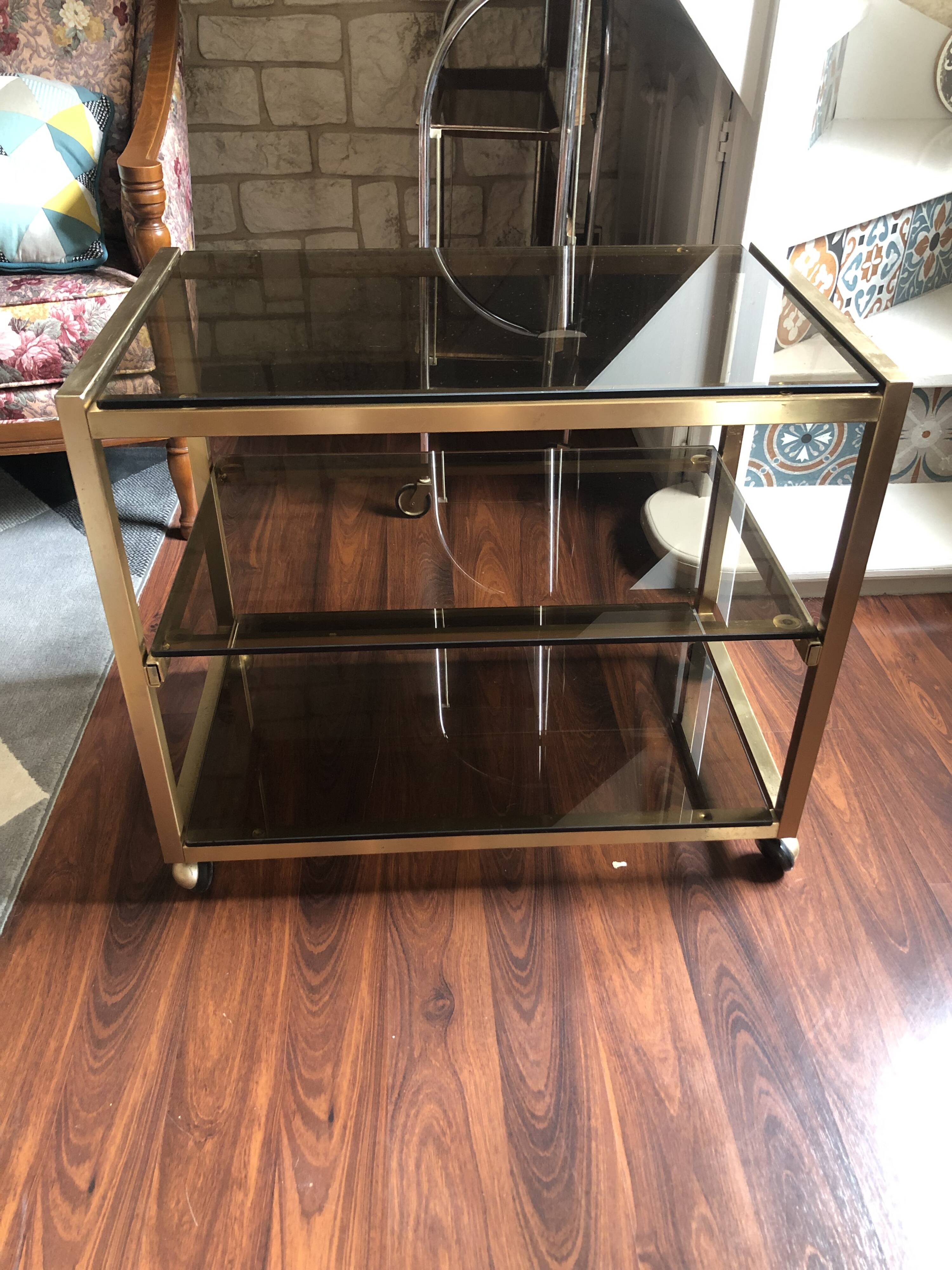 Vintage brass serving trolley with smoked glass trays.