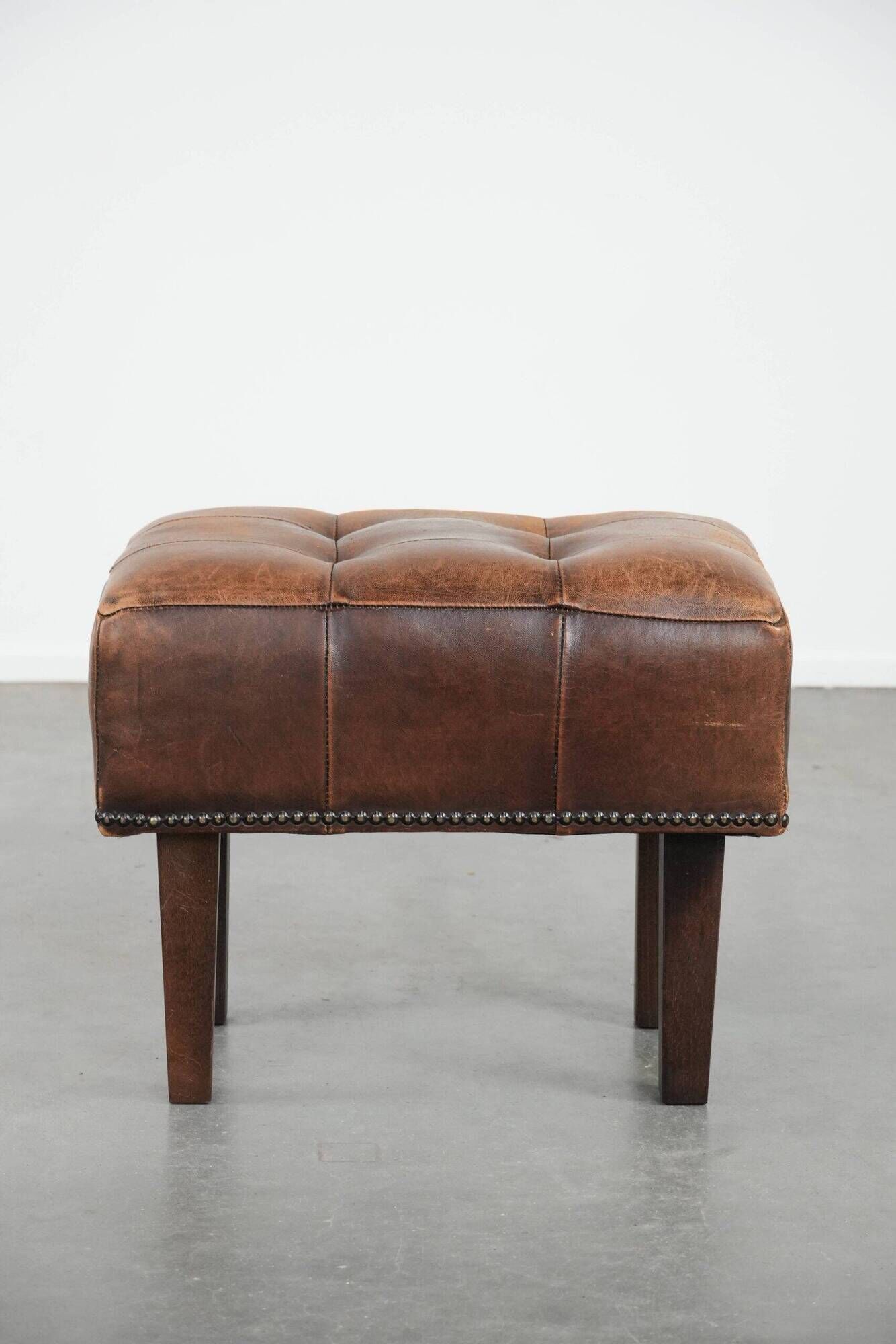 Beautiful sheepskin ottoman on high legs and beautiful warm colours
