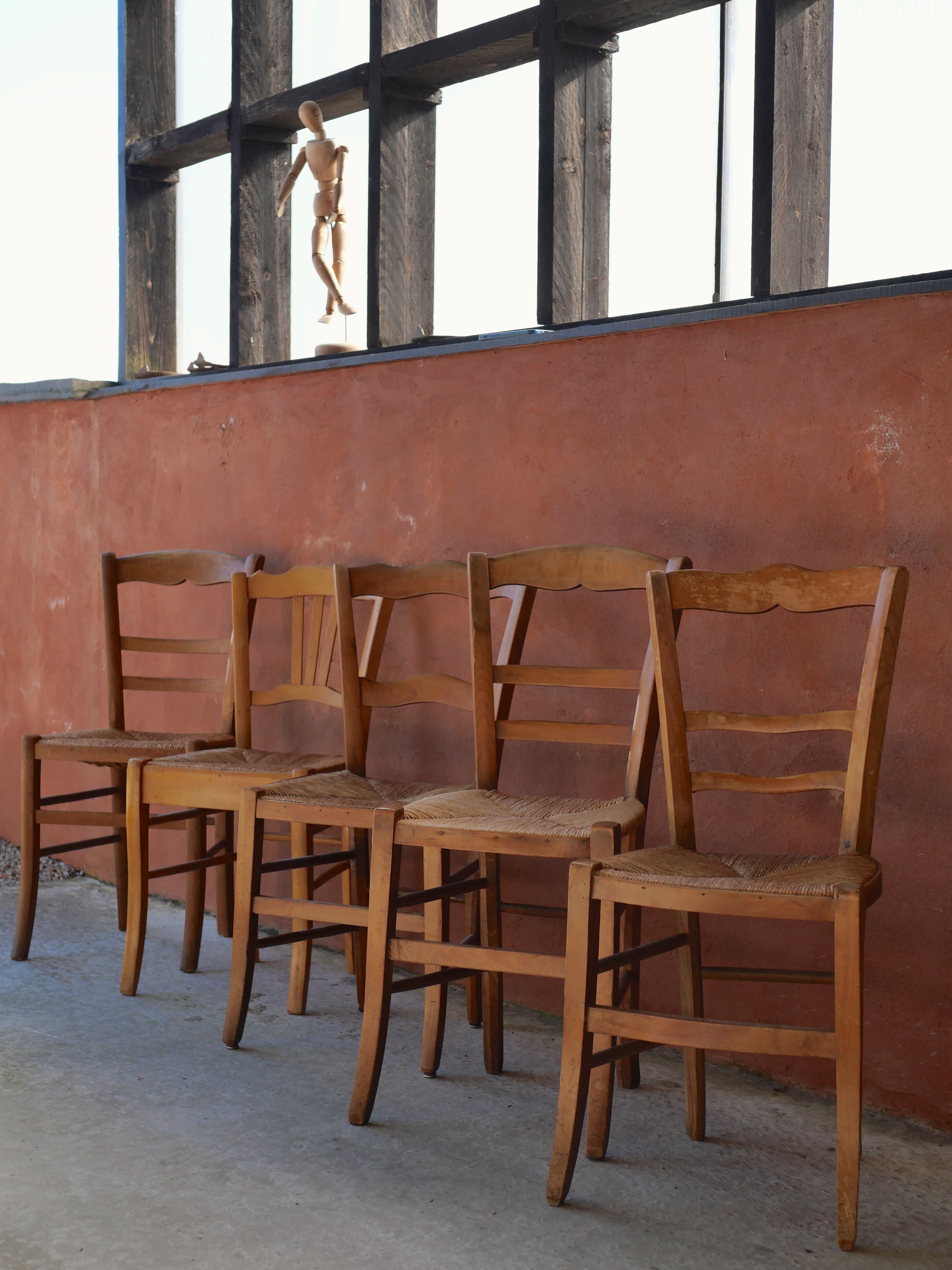 Set of 5 mismatched straw chairs.