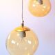Set of 2 bubbled amber glass globe pendants