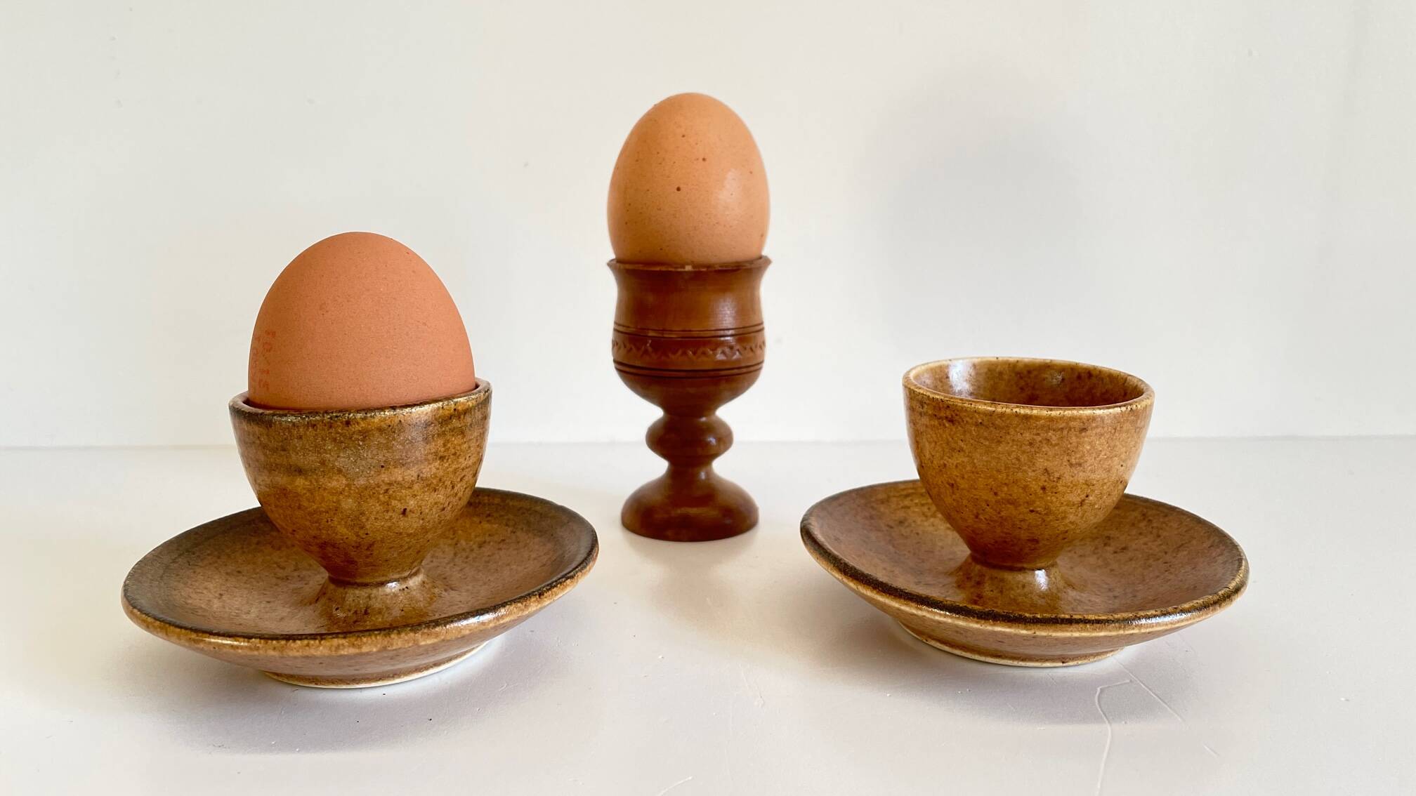 Trio of vintage ceramic and wood egg cups