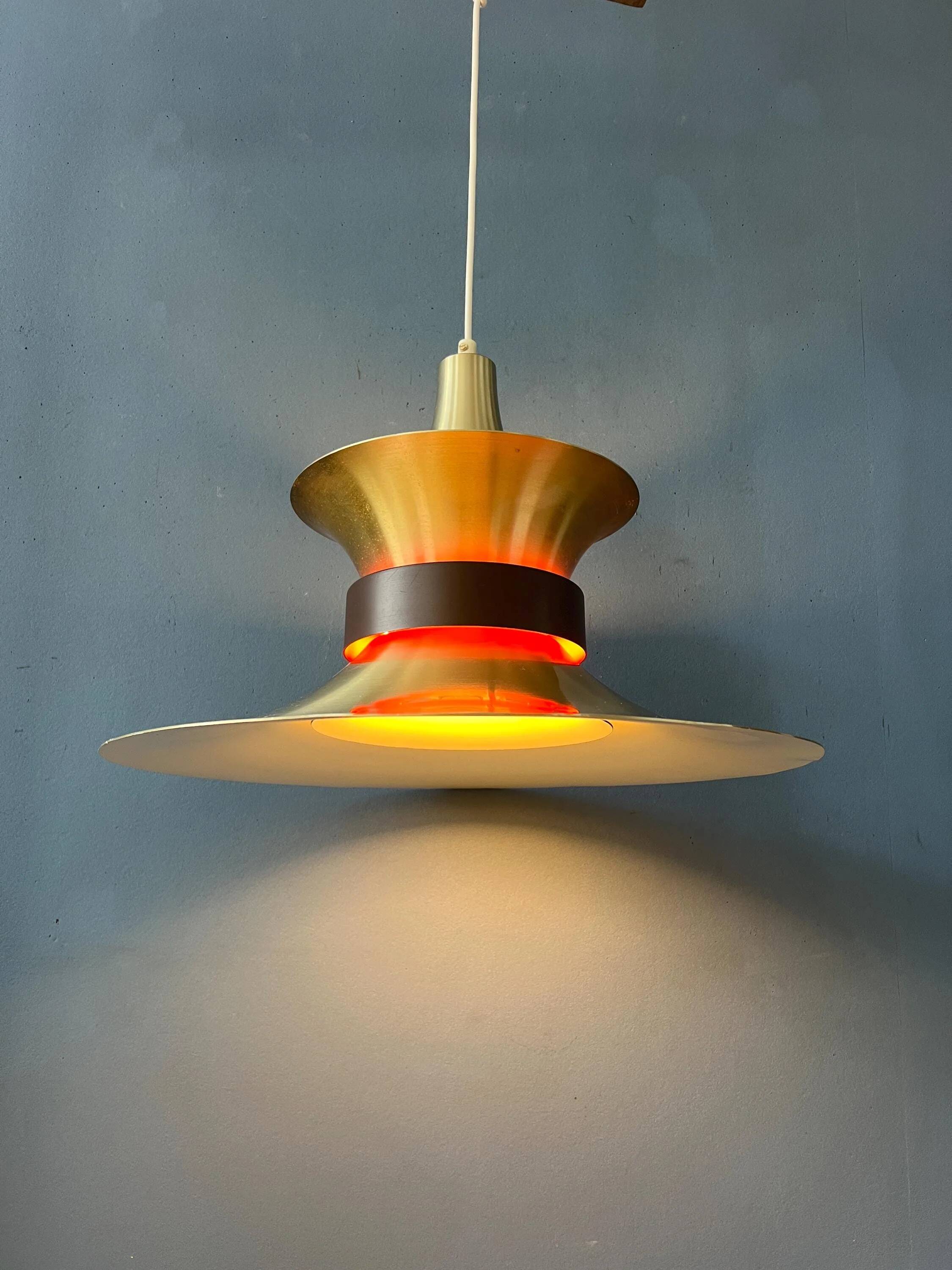 Large UFO flying saucer pendant light with orange light.