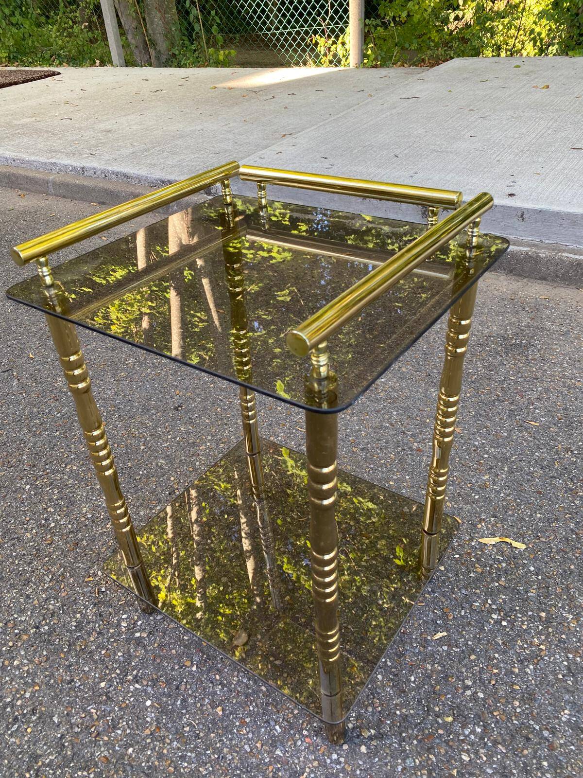 Vintage side table with smoked glass and sculpted golden brass, Hollywood Regency style.