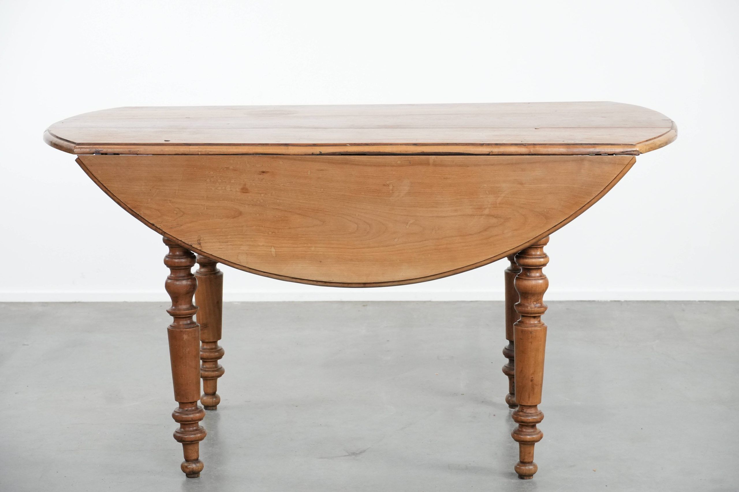 Antique English drop-leaf dining table made of walnut with elegant legs
