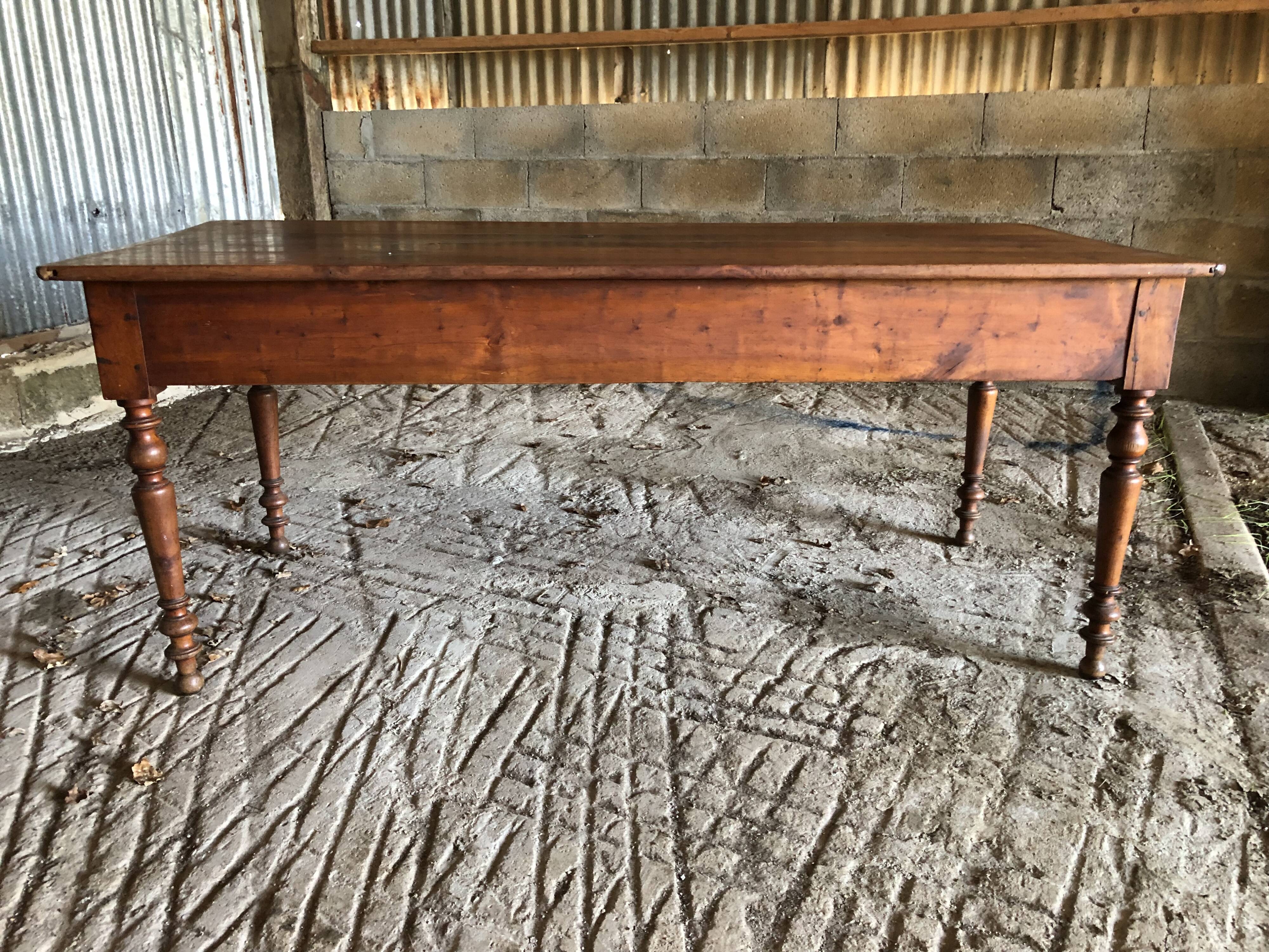 Antique Louis Philippe style farm table in solid cherry wood with turned base.