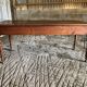 Antique Louis Philippe style farm table in solid cherry wood with turned base.