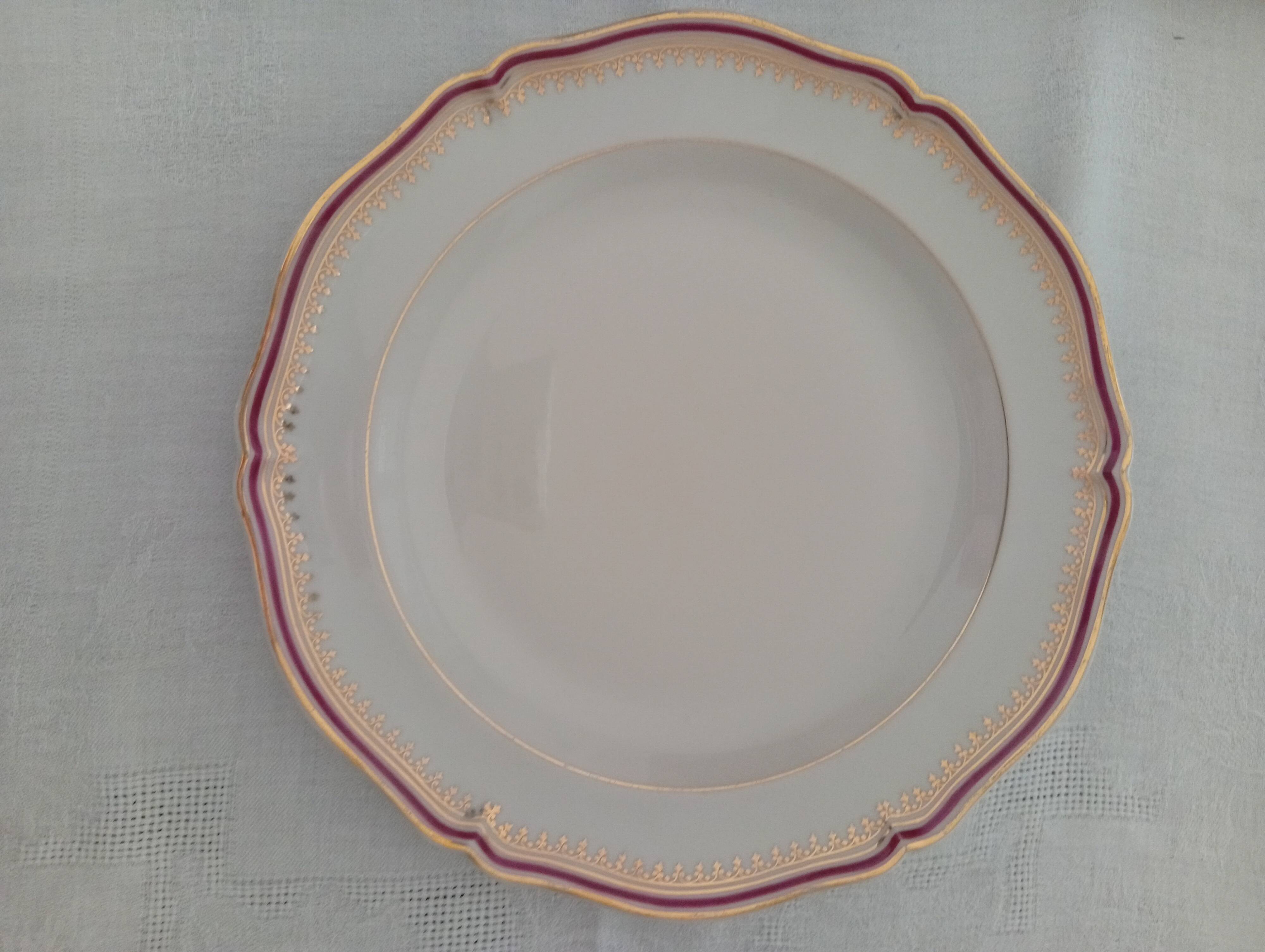 Set of 12 stylised white porcelain dinner plates, signed.