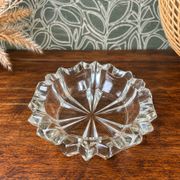 Vintage transparent glass ashtray with star decoration.