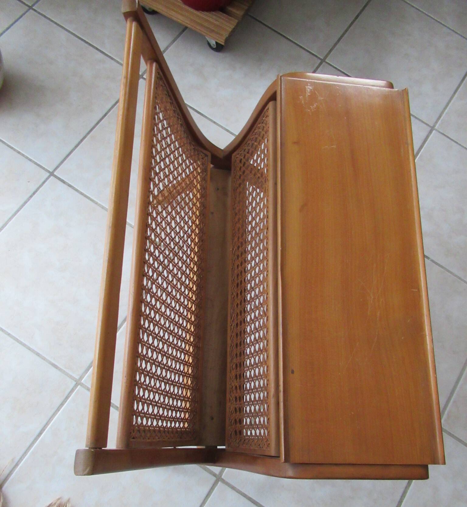Cane magazine rack with light wood shelf