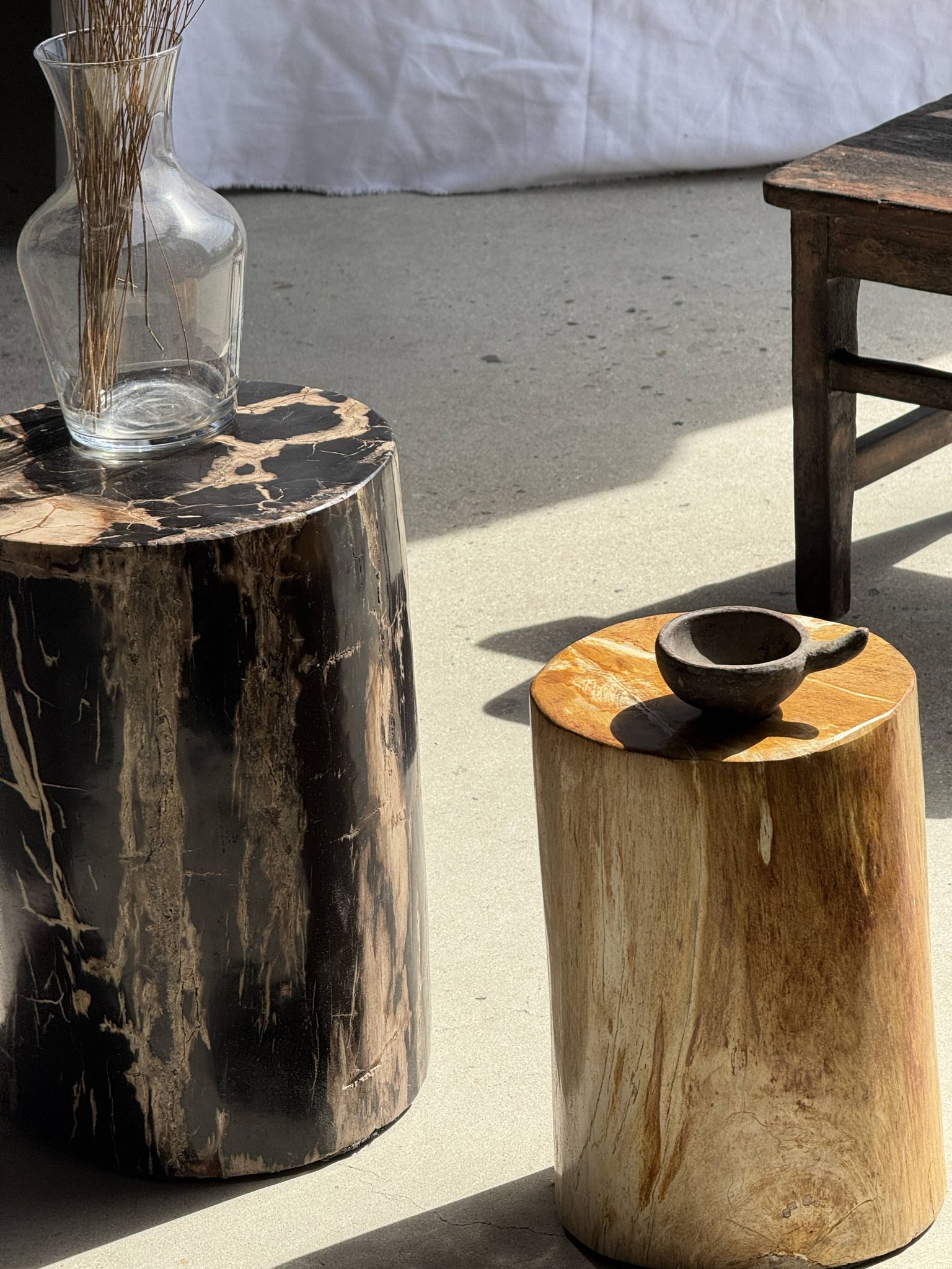 Black petrified wood side table with beige stripes and a semicircular shape.