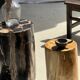 Black petrified wood side table with beige stripes and a semicircular shape.