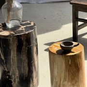Black petrified wood side table with beige stripes and a semicircular shape.