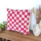 Berber cushion with a pink checkerboard pattern.