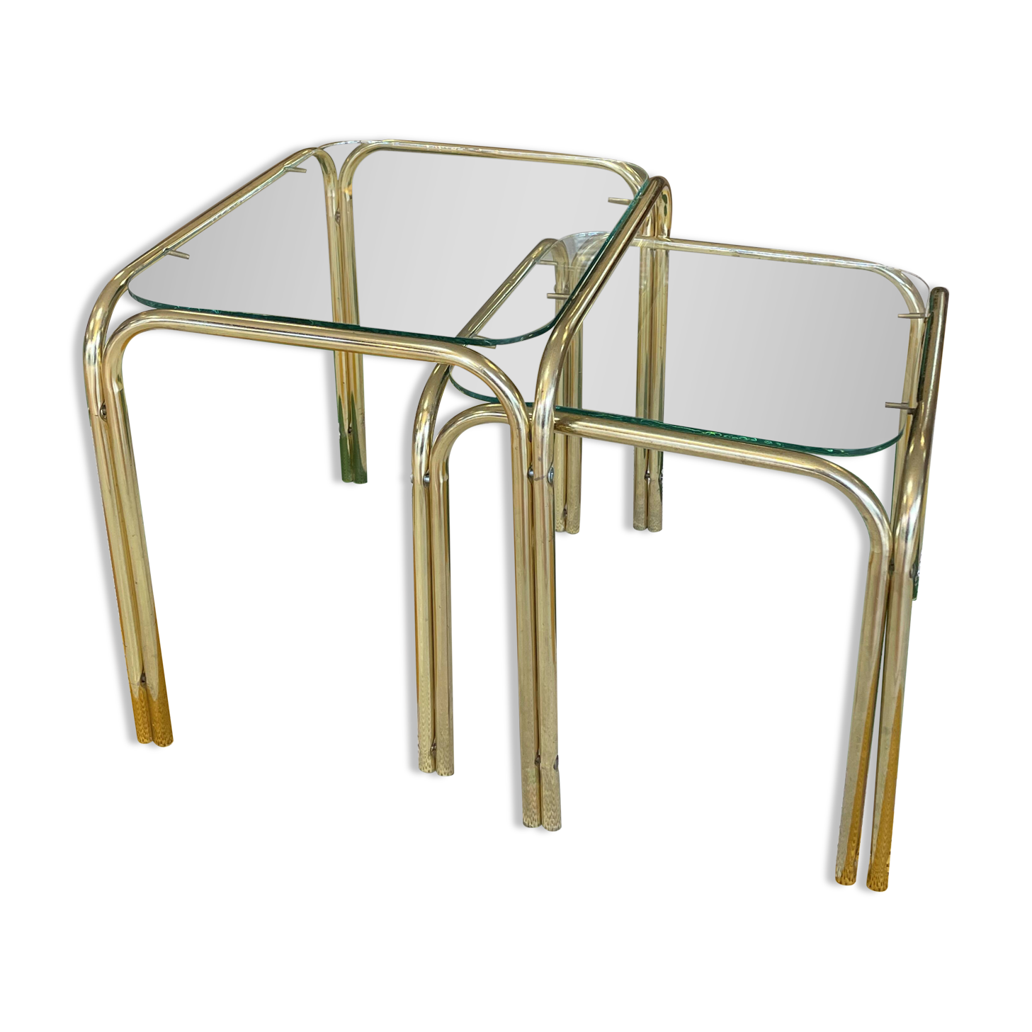 Pair of small nesting coffee tables in gold tubular metal & transparent glass tops