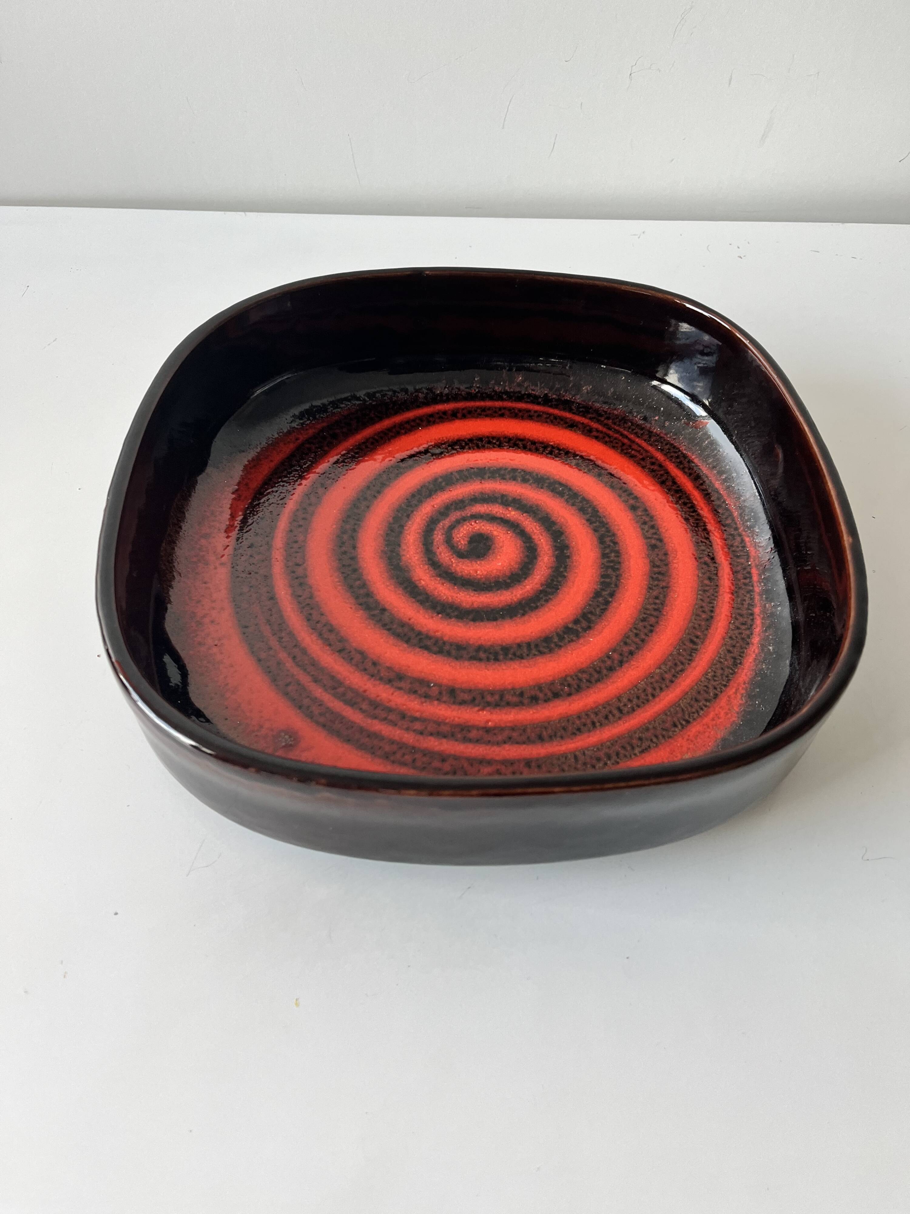 Large decorative ceramic catchall with red and black spiral pattern.