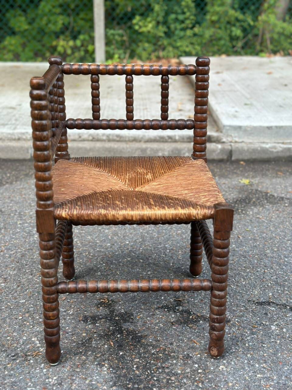 Brutalist corner chair in turned wood with straw bobbins, 1960.