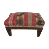 Natural wood footrest upholstered in striped fabric.
