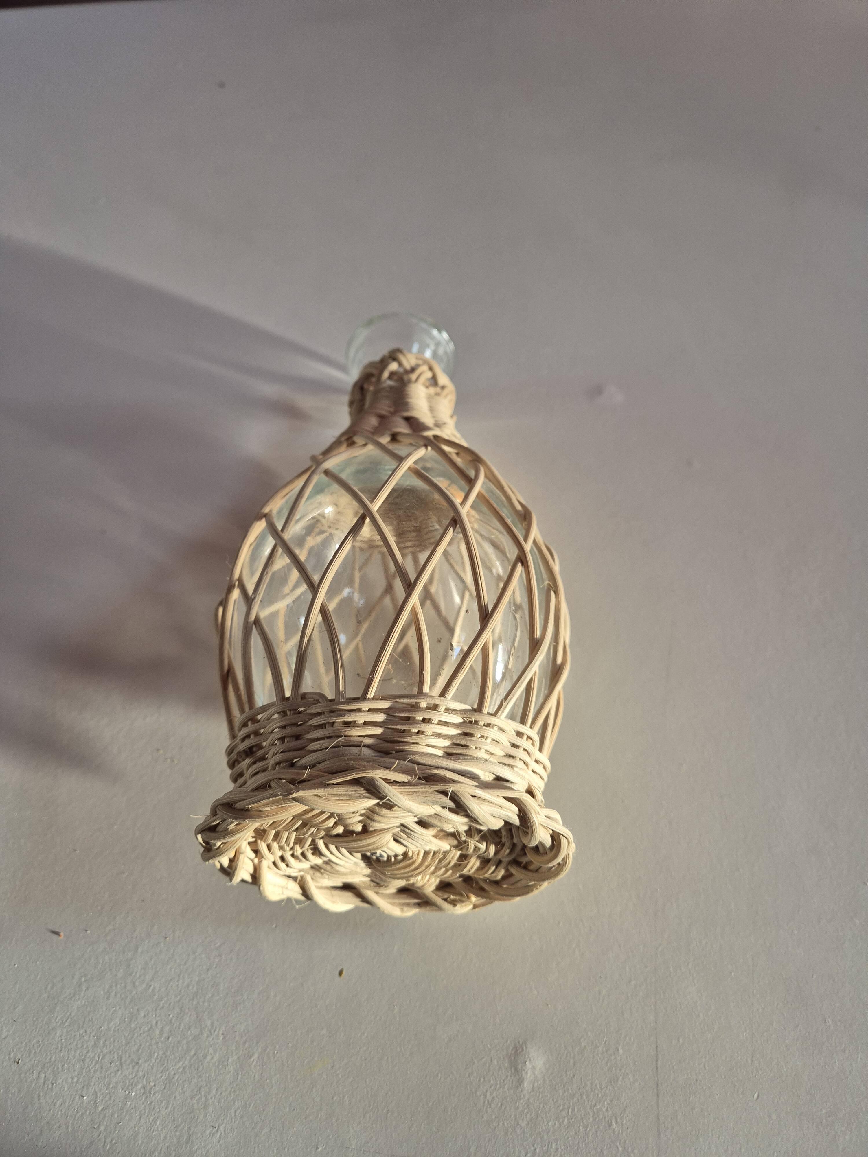 vintage glass vase surrounded by woven rattan