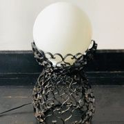 Black wrought iron lamp with a white glass globe.