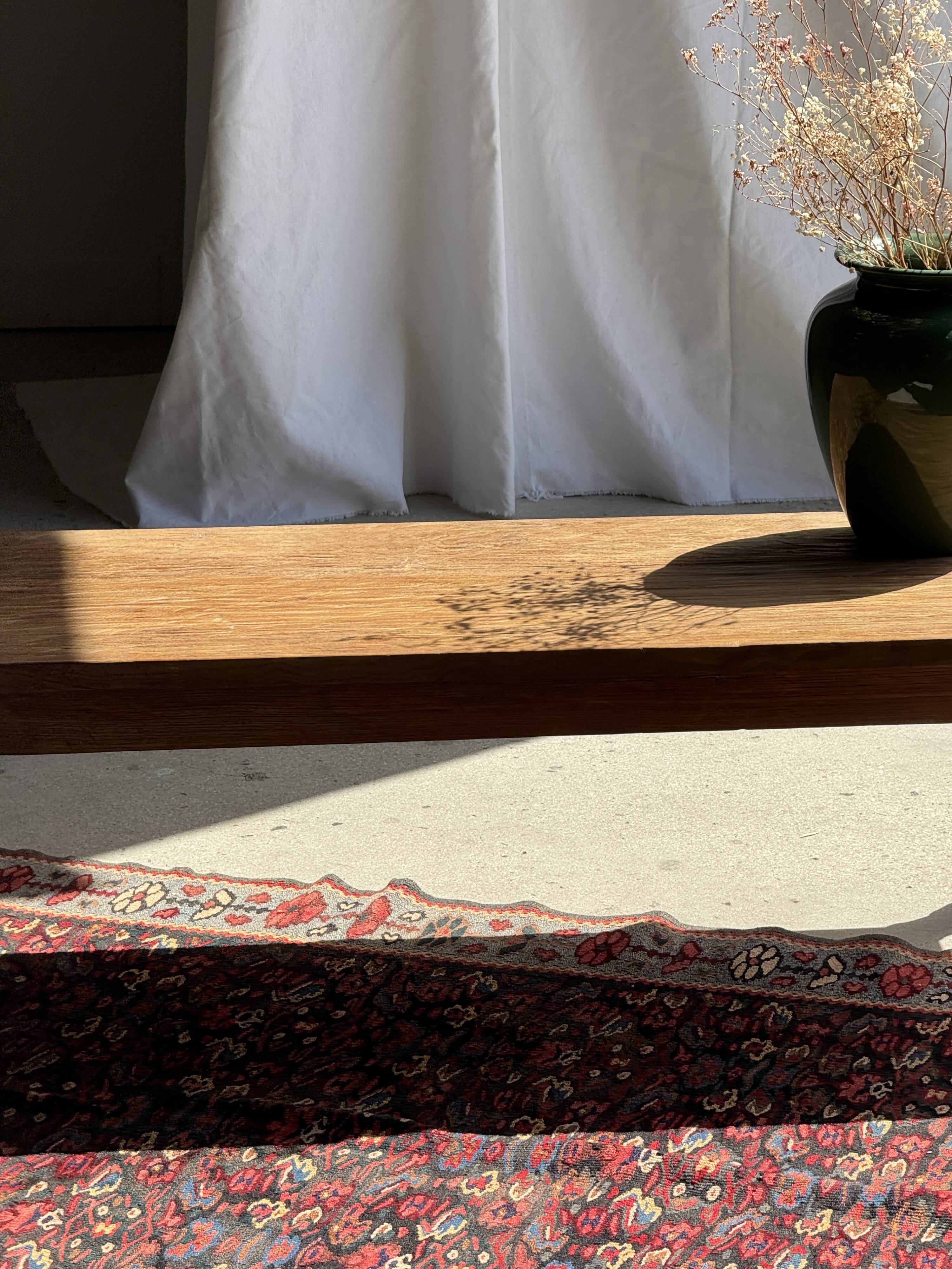 Brown Indonesian teak coffee table, with a border and cylindrical legs H40 L103.