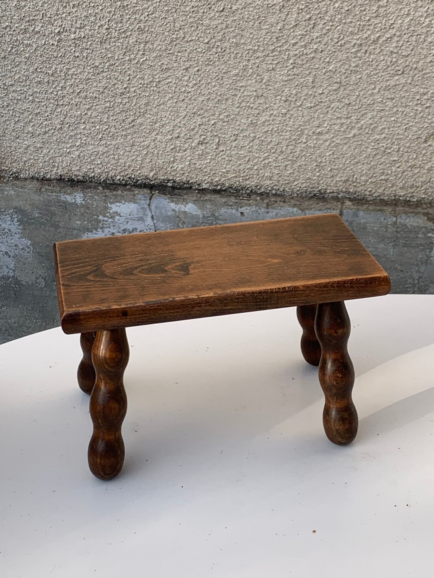 Footstool in varnished wood turns old