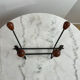 Wall-mounted coat rack in wrought iron with turned wooden knobs.