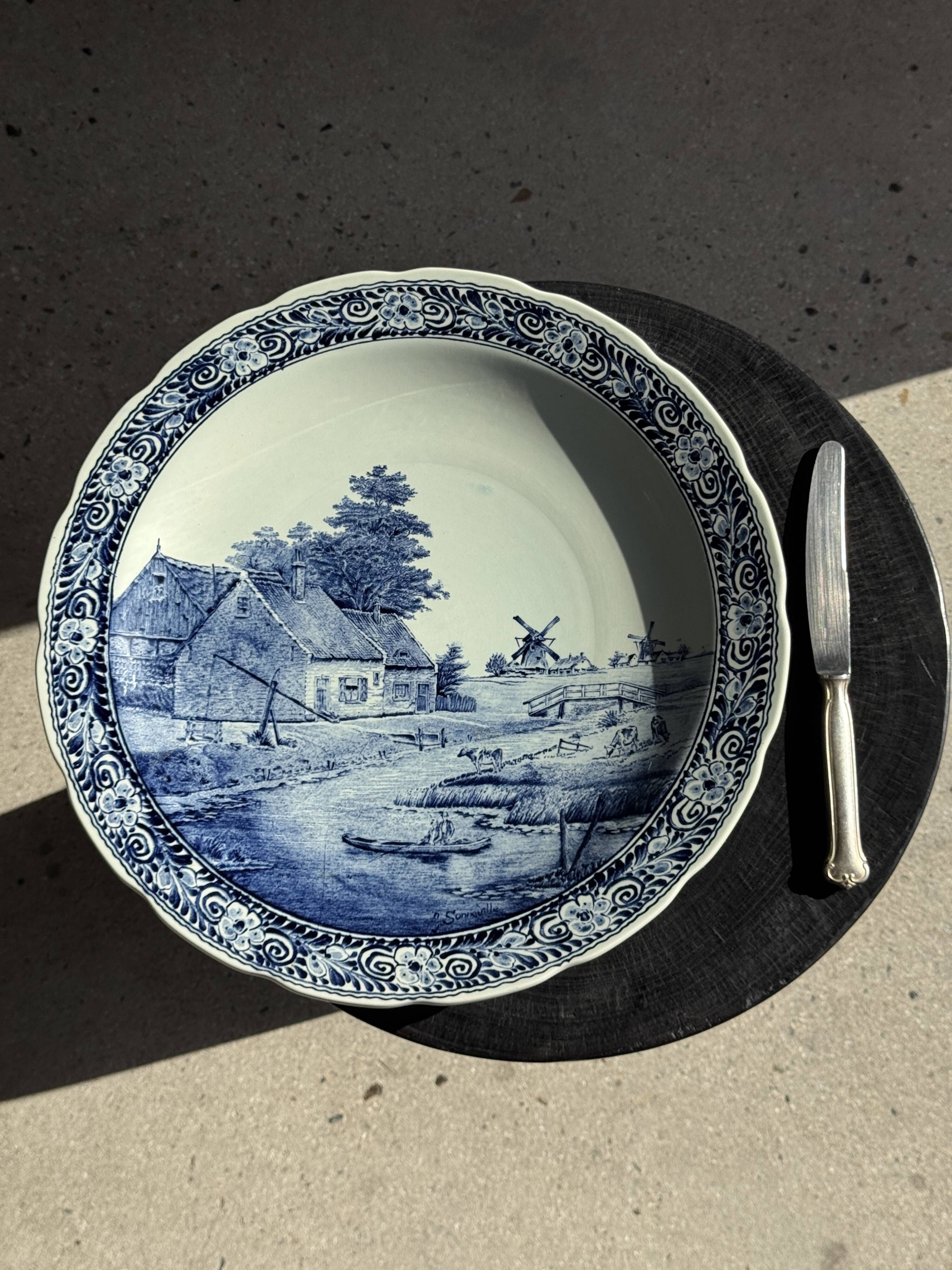Vintage hollow circular plate in blue and white Boch pottery.