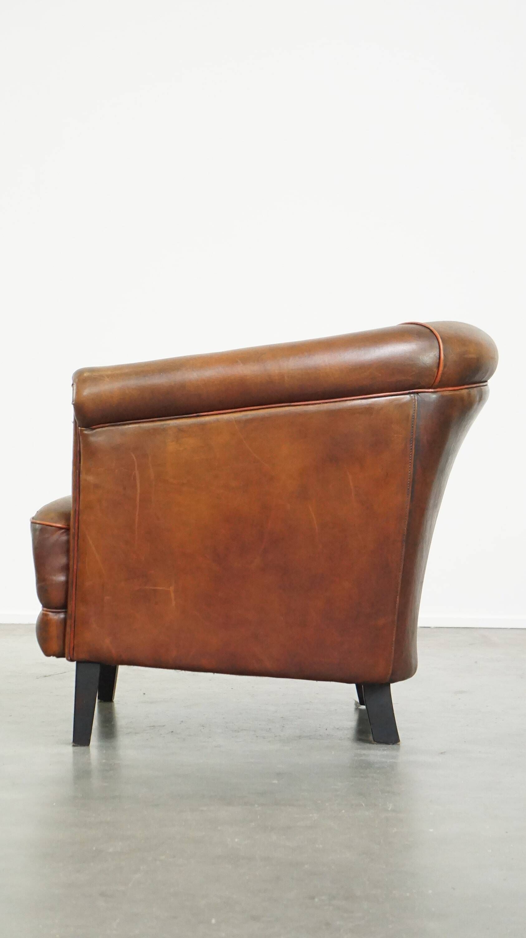 Neat, elegantly finished, cozy sheepskin club armchair with a fixed seat cushion